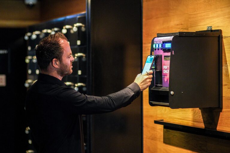 Bezoeker rekent contactloos af bij de wisselautomaat naast de clublockers
